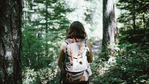 Mädchen im Wald Mädchen von Hinten mit einem Rucksack im Wald