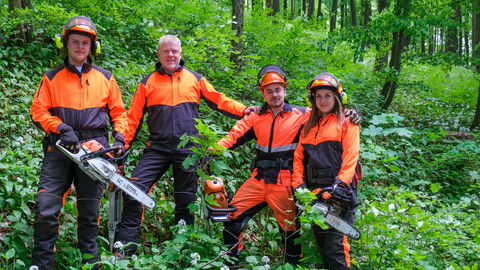 Forstwirtausbildung bei HessenForst Drei Auszubildende der Forstwirtschaft stehen mit ihrem Ausbilder im Wald und haben Motorsägen in der Hand