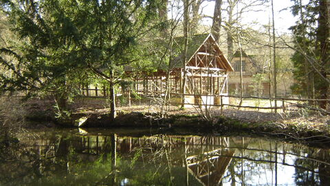 Vorne im Bild ist ein Teich, dahinter liegt ein Kaffeehalle