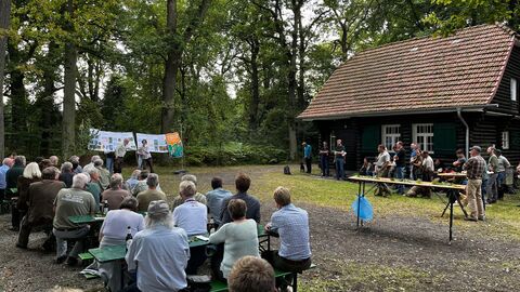 Ein Blick auf das Veranstaltungsgelände und auf die zahlreichen Gäste an der Jagdhütte „Blockhaus“ Publikum vor dem Blockhaus im Reinhardswald