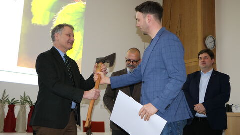 Landesbetriebsleiter Dr. Bernhard von Finckenstein überreicht die Forstaxt für den Jahrgangsbestenan Julius Eckhardt-Eiff.