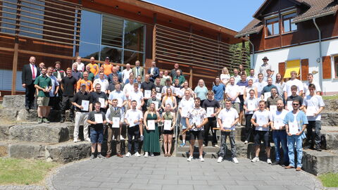 Die Gruppe der neuen Forstirtinnen und Forstwirte nebst Ausbildungsteam und Leitung stehen auf der Treppe vor dem Haus Lärche des Forstlichen Bildungszentrums Weilburg